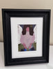 an angelic art print in a black frame with a white mat sitting on a white table 