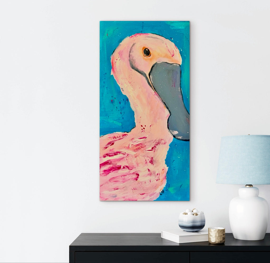 roseate spoonbill canvas print hangs over a table with a lamp and trinkets on it