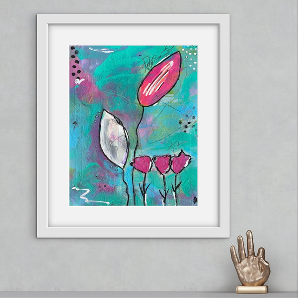 Framed abstract art print with pink flowers on a gray wall.
