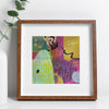 Framed abstract artwork with a colorful design on a white wall.