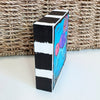 a square wood block on a table in front of a basket
