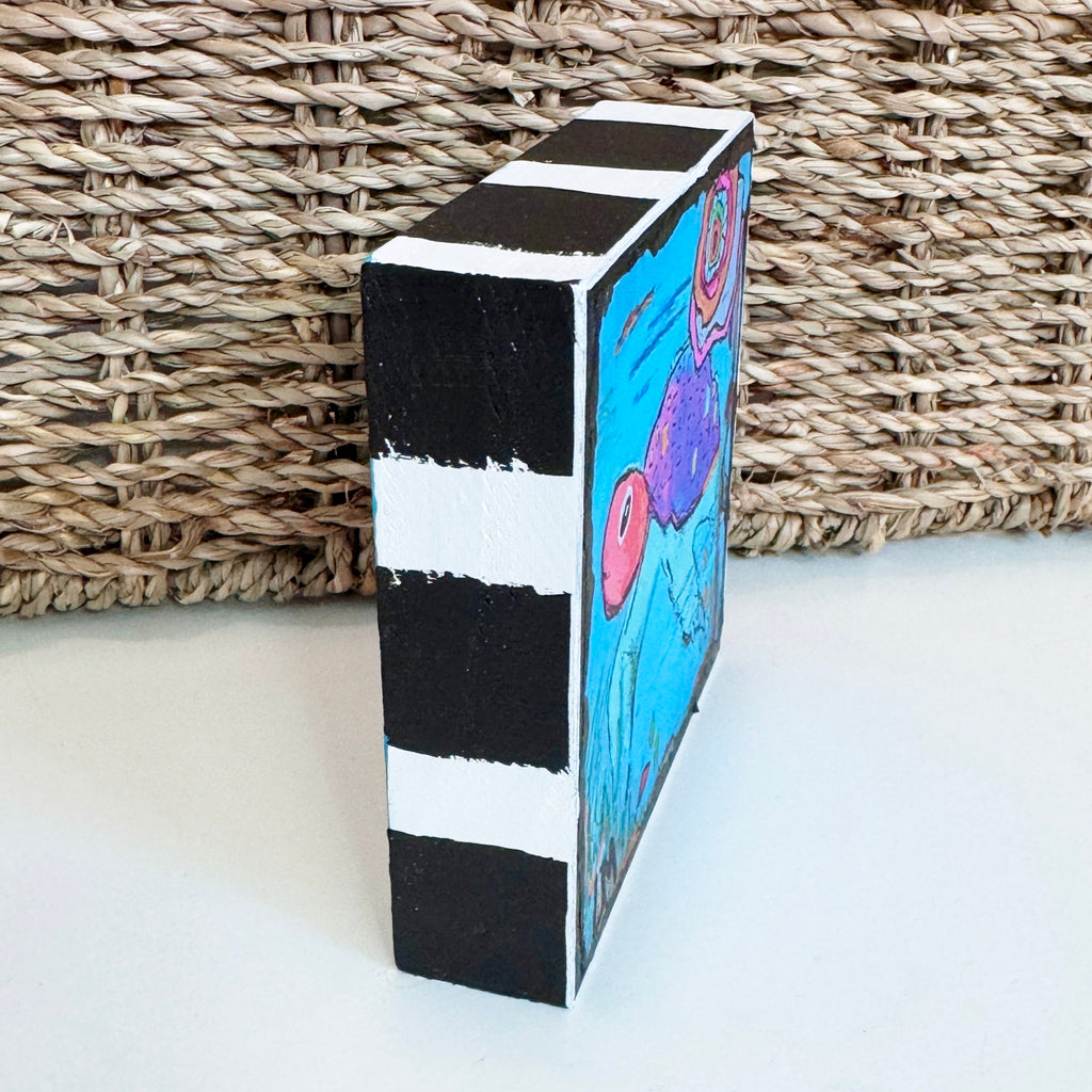 a square wood block on a table in front of a basket