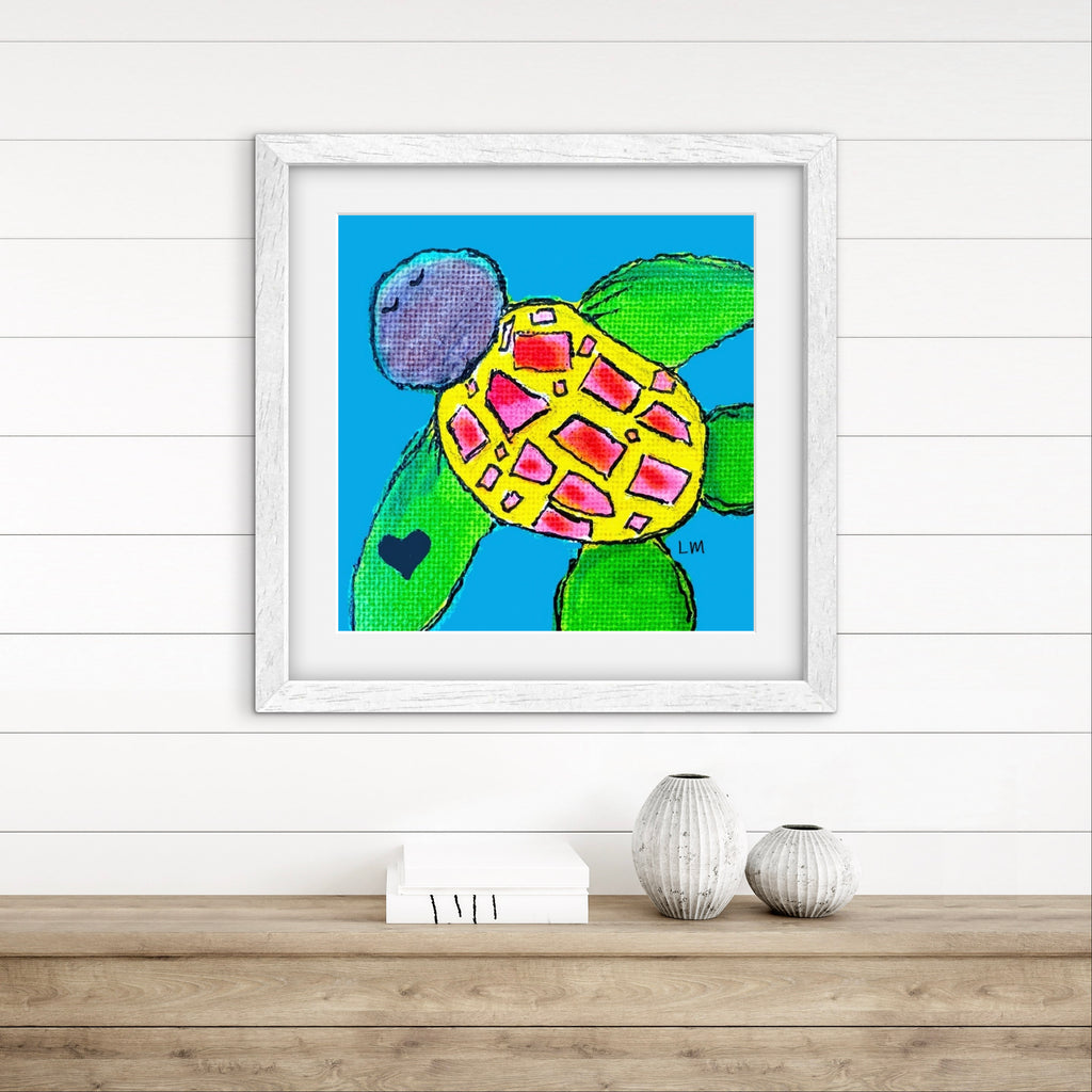 Framed artwork of a colorful turtle on a white wall above a wooden surface with decorative items.