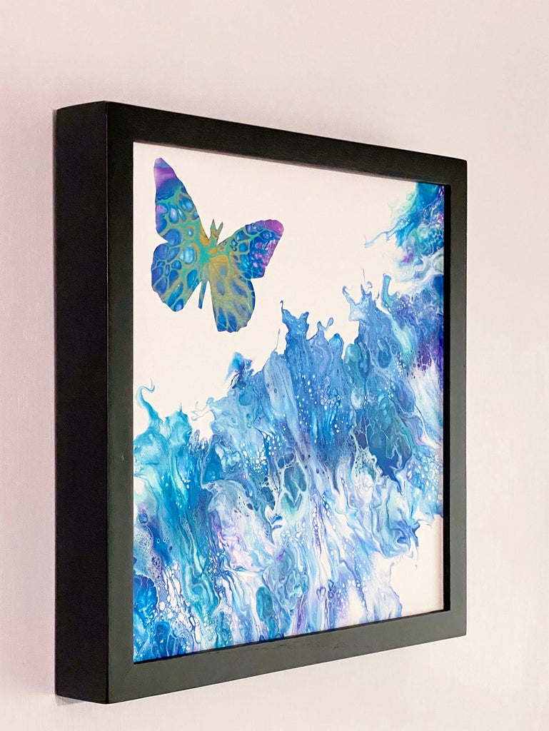 Expansion butterfly painting viewed from the left in a black gallery frame on a light wall