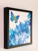 Expansion butterfly painting viewed from the left in a black gallery frame on a light wall