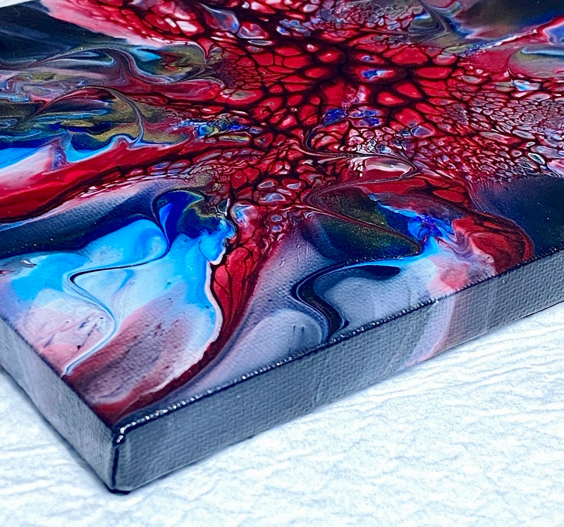 Acrylic pour abstract painting inspired by Spider-Man. Small 6x8 canvas done in black, red, white, blue and gold. Measures 0.50 inch depth. This would be perfect in a boys room. Created by artist Lori McKinnon from Pizazz Studios